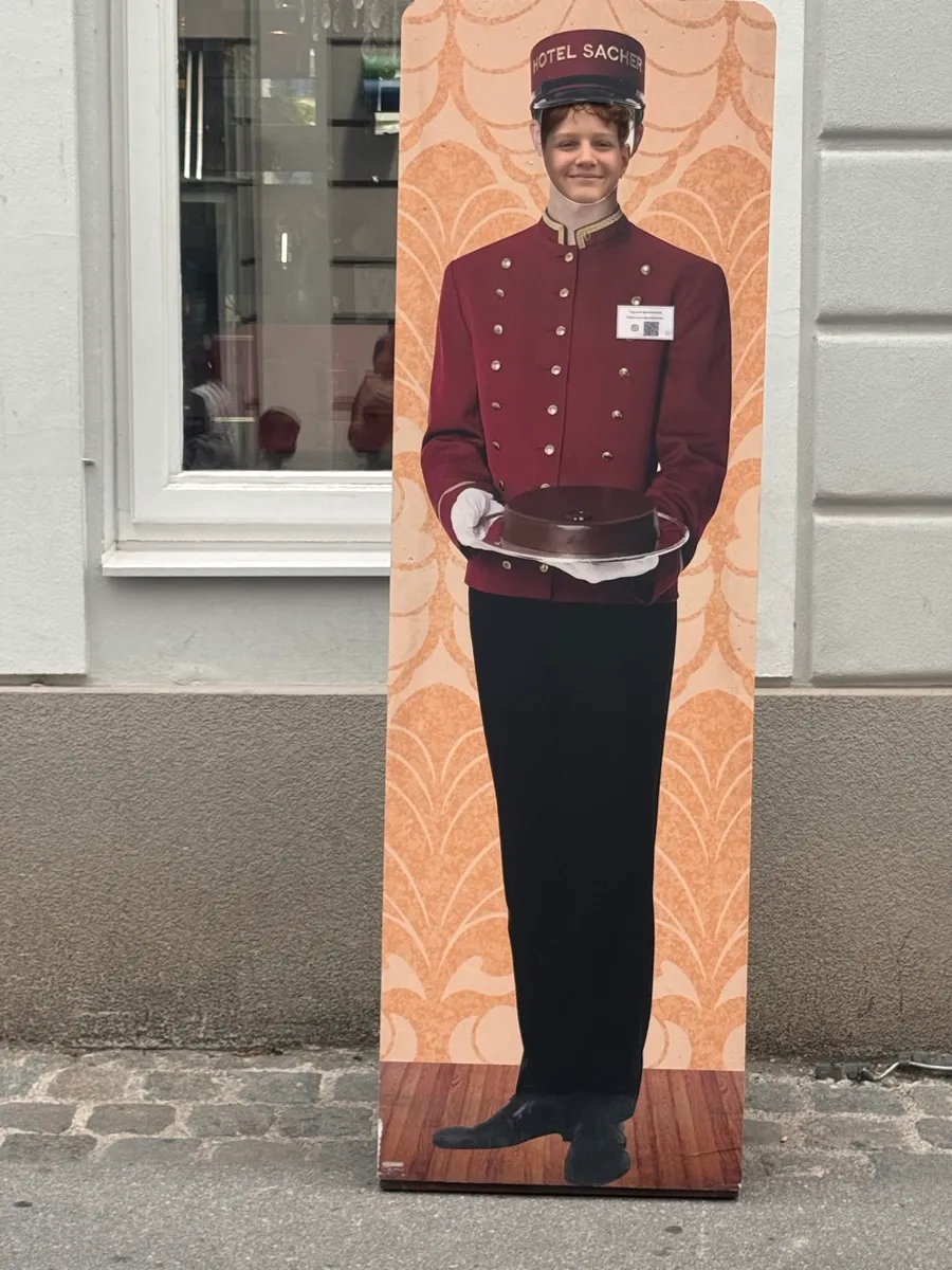 Eine lebensgroße Figur steht vor einem Gebäude.