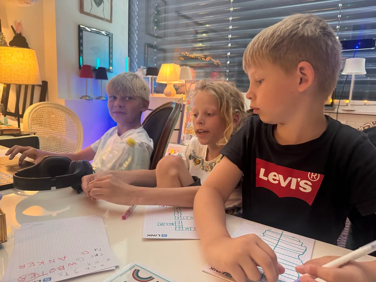 Kinder arbeiten gemeinsam an einem Tisch in einem Unterrichtsraum.