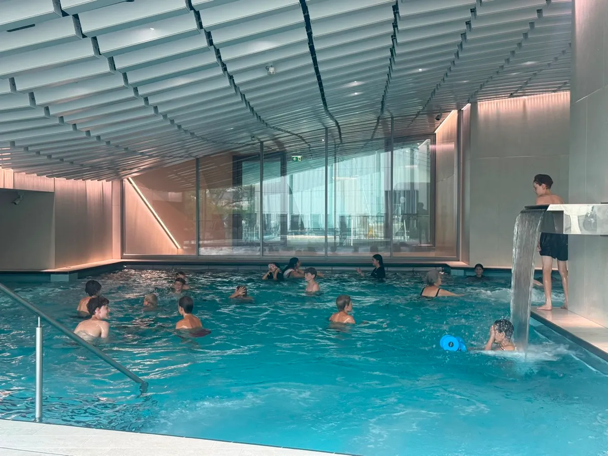 Kinder schwimmen gemeinsam in einem Hallenbad.